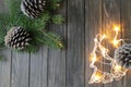 Christmas background with fir branches and big pine cones on dark wooden background and lights Royalty Free Stock Photo