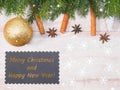 Christmas background with fir branches, cone, present, snowflakes, toy, cinnamon, anise and nameplate on brown wooden background. Royalty Free Stock Photo