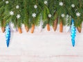 Christmas background with fir branches, cone, snowflakes, toys, cinnamon on brown wooden background Royalty Free Stock Photo
