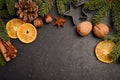 Christmas background with fir branches, cones, nuts and slices of dried orange.