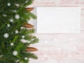 Christmas background with fir branches, cones, snowflakes, white tablet on brown wooden background Royalty Free Stock Photo