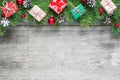 Christmas background with fir branches, decorations, gift boxes and pine cones on rustic wooden table Royalty Free Stock Photo