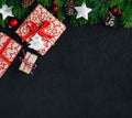 Christmas background with fir branches and a gift box with a red bow on a dark concrete background Royalty Free Stock Photo