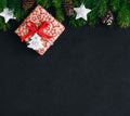 Christmas background with fir branches and a gift box with a red bow on a dark concrete background Royalty Free Stock Photo