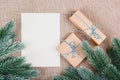 Christmas background with fir branches and gifts. Gift Boxes and blank paper sheet Royalty Free Stock Photo