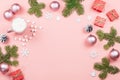 Christmas background with fir branches, lights, red giftboxes, pink decorations, hot drink with marshmallows on pink Royalty Free Stock Photo