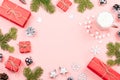 Christmas background with fir branches, lights, red giftboxes, pink decorations, hot drink with marshmallows on pink Royalty Free Stock Photo