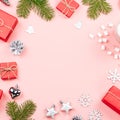 Christmas background with fir branches, lights, red giftboxes, pink decorations, hot drink with marshmallows on pink Royalty Free Stock Photo