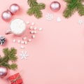 Christmas background with fir branches, lights, red giftboxes, pink decorations, hot drink with marshmallows on pink Royalty Free Stock Photo
