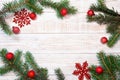 Christmas background - fir branches and red decorations on a white wood table. Flat layout, top view composition border with copy Royalty Free Stock Photo