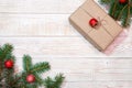 Christmas background - fir branches with red ornaments and a gift box on a white wood table. Flat layout, top view composition Royalty Free Stock Photo