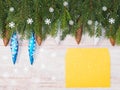 Christmas background with fir branches, snowflakes, toys, cones, yellow envelope on brown wooden background Royalty Free Stock Photo