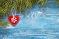 Christmas background with fir branches and winter heart on blue