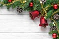 Christmas background with fir tree, christmas bells, berries, decorations and pine cones on white wooden table Royalty Free Stock Photo