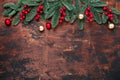 Christmas background with fir tree branches, holly and christmas balls on wooden table. Copy space for your text Royalty Free Stock Photo