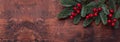 Christmas background with fir tree branches and holly. Top view. Horizontal banner. Copy space Royalty Free Stock Photo