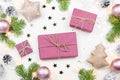 Christmas background with fir tree branches, purple giftboxes, Christmas lights, pink decorations, silver ornaments Royalty Free Stock Photo