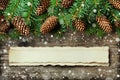 Christmas background of fir tree and conifer cone on old vintage wooden board, fantastic snow effect and aged paper with copy spac