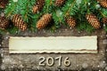 Christmas background of fir tree and conifer cone on old vintage wooden board, fantastic snow effect, wooden numbers of New year a