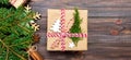 Christmas background with fir tree and gift box on wooden table. Top view with copy space banner for your design Royalty Free Stock Photo