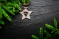 Christmas background. Fir tree with wooden star on dark slate table. Top view with copy space