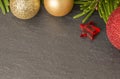 Christmas background with firtree, baubles and stars on slate close up Royalty Free Stock Photo