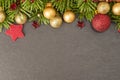 Christmas background with firtree, baubles and stars on slate Royalty Free Stock Photo