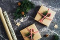 Christmas background. Flat lay gift boxes, wrapping paper, fir branches and wooden decorations on stone table Royalty Free Stock Photo