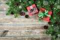 Christmas background with gift box, fir branch and conifer cone on wooden rustic board, festive snow effect, Christmas frame Royalty Free Stock Photo