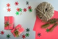 Christmas background with gift boxes, clews of rope, paper and decorations on red. Preparation for holidays Royalty Free Stock Photo