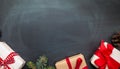 Christmas background with gift boxes and gingerbread cookies on blackboard.