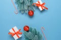 Christmas background. Gift boxes, spruce branch with red balls and candy cane on a blue paper background. Top view, flat Royalty Free Stock Photo