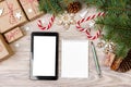 Christmas background with gift boxes, tablet with white screen and blank notebook, copy space. Template for new year goal or resol Royalty Free Stock Photo