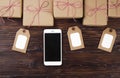 Smart phone with christmas presents on wooden background top view. Online holiday shopping concept. Flat lay, text space. Internet Royalty Free Stock Photo