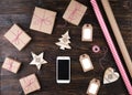 Smart phone with christmas presents on wooden background top view. Online holiday shopping concept. Flat lay, text space. Internet Royalty Free Stock Photo