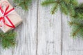 Christmas background with gift and fir tree on white wooden table. Top view with copy space. Royalty Free Stock Photo