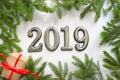 Christmas background with gift, Christmas tree and numbers 2019 on white wooden table. Royalty Free Stock Photo