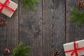 Christmas background with gifts, fir branches and pinecones over black wooden table Royalty Free Stock Photo