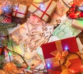 Christmas background. Gifts for loved ones. Money of different values. The atmosphere of Xmas. Top view. Effect of light blips Royalty Free Stock Photo