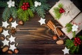 Christmas background with gingerbread cookies, fir branches and presents in boxes on the old wooden board. Copy space. Royalty Free Stock Photo