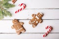 Christmas background. Gingerbread men and Christmas cane on a white wooden background.