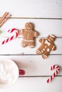 Christmas background. Gingerbread men and Christmas cane on a white wooden background Royalty Free Stock Photo