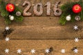 Christmas background with gingerbread numbers 2016, fir branches and decorations with frame for your text on the old wooden board. Royalty Free Stock Photo