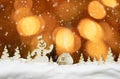 Christmas background with golden bokeh lights, falling snow, snowman, hut and magic forest Royalty Free Stock Photo