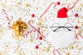 Christmas background of golden confetti, holiday decorations and funny Santa on white table top view. Flat lay Royalty Free Stock Photo
