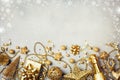 Christmas background with golden gift or present box, champagne and holiday decorations top view. Greeting card. Flat lay style