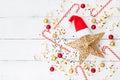 Christmas background of golden star with Santa hat, holiday decorations and confetti top view. Flat lay. Royalty Free Stock Photo