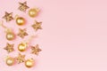 Christmas background - golden stars and sparkling glittering balls on soft light pastel pink background, border, copy space. Royalty Free Stock Photo