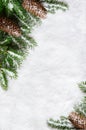 Christmas background, green pine branches, cones on snow background. Creative composition with border and copy space, top view. Royalty Free Stock Photo