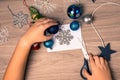 Christmas background with the hands of a child preparing New Year`s decorations on a wooden table. View from above Royalty Free Stock Photo